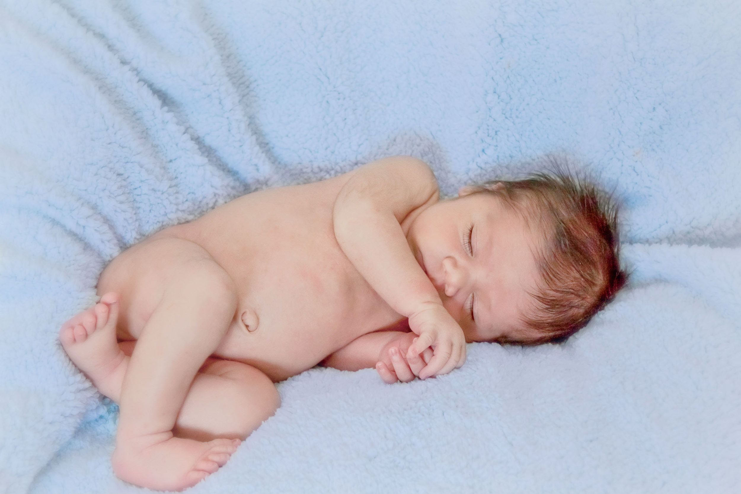 Portrait of a newborn boy sleeping on his fuzzy blanket