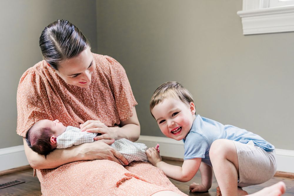Cozy indoor family scene showing a newborn and sibling resting together.