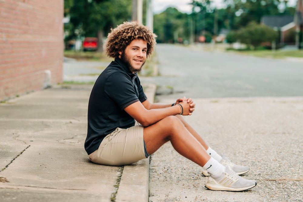 Casual portrait of person sitting on concrete steps in an urban setting.