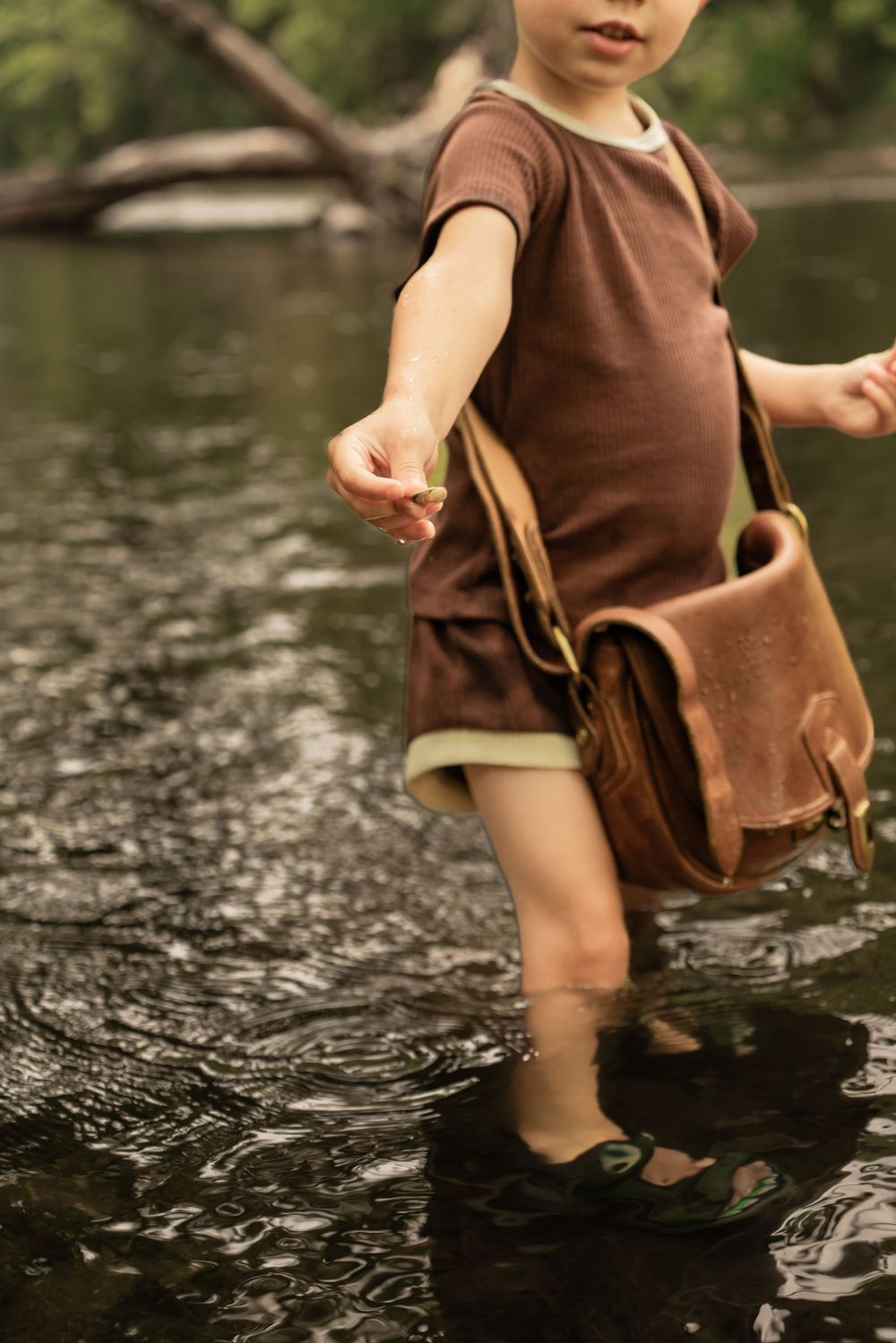 boy holds out treasured shell found in river