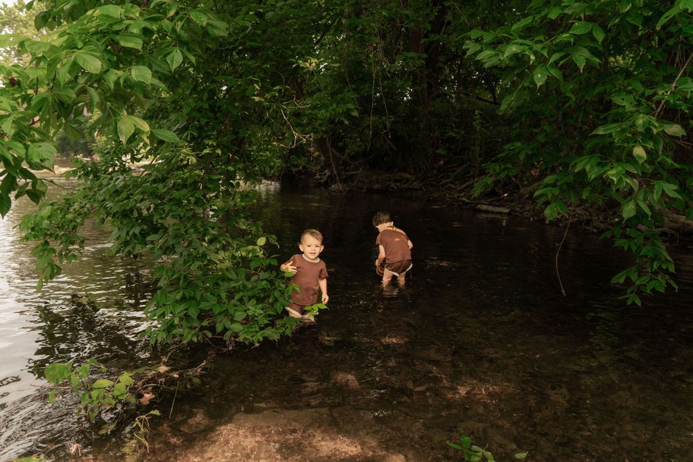 brothers explore river shallows together