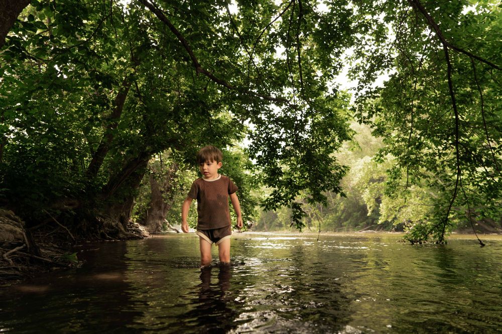 boy stands in river