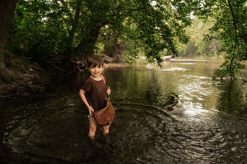 boy looks downstream for ducks on river