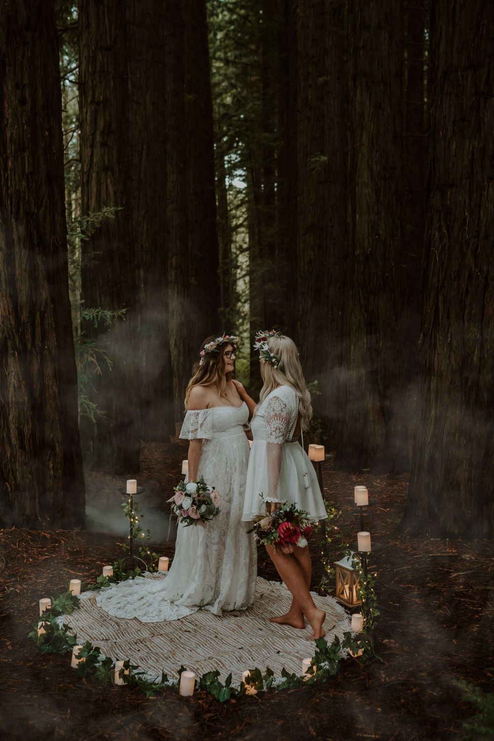 White lace dresses and floral arrangements create an ethereal scene in a misty forest.