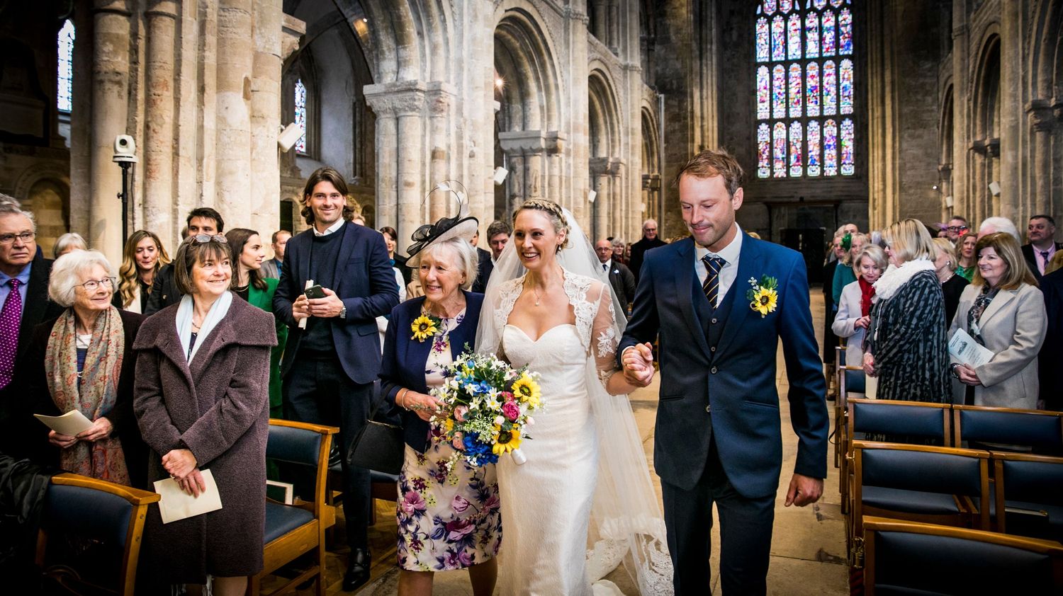 Gothic cathedral interior with stunning stained glass windows and vaulted arches during ceremony.