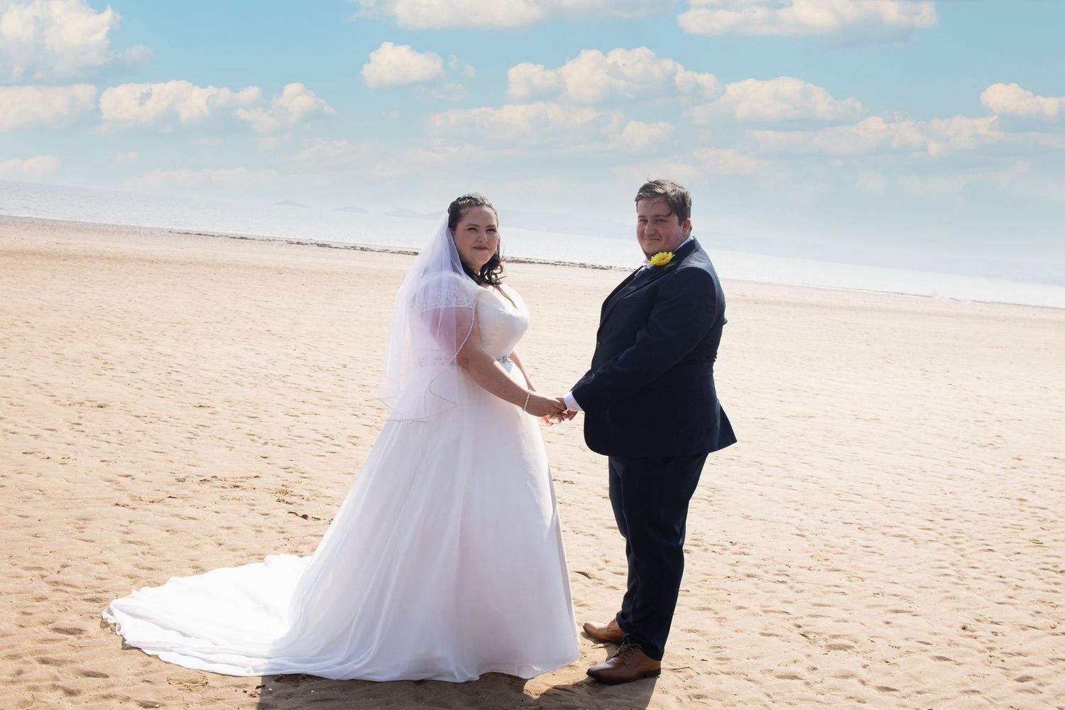 bride and groom at beach holding hands photographed by wedding photographer swansea