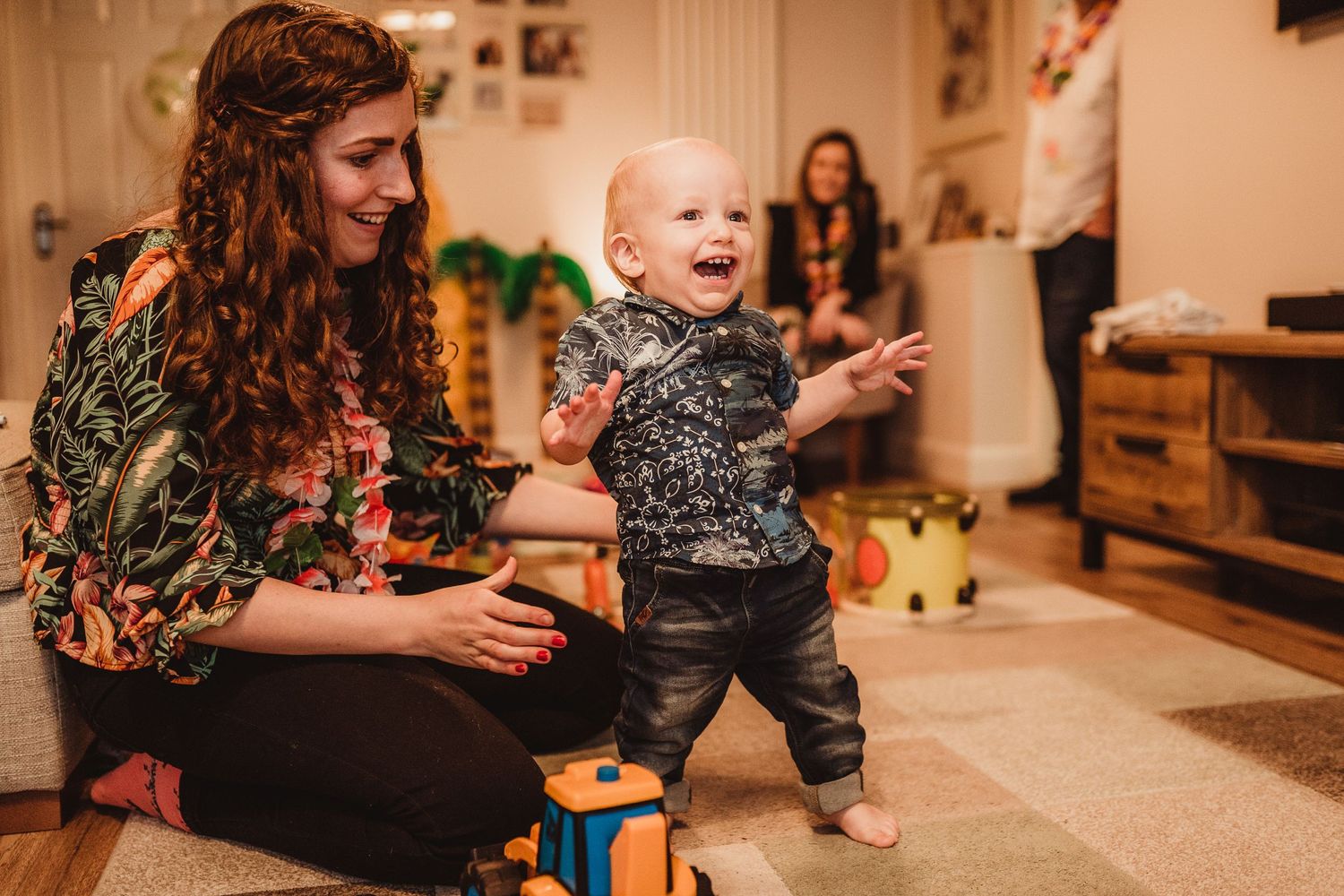 One-year-old very nearly taking his first steps as he wobbles and is about to fall over, his face has the biggest smile