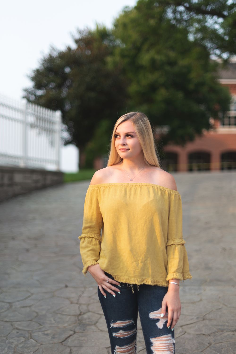Outdoor portrait on textured concrete wearing casual summer attire.