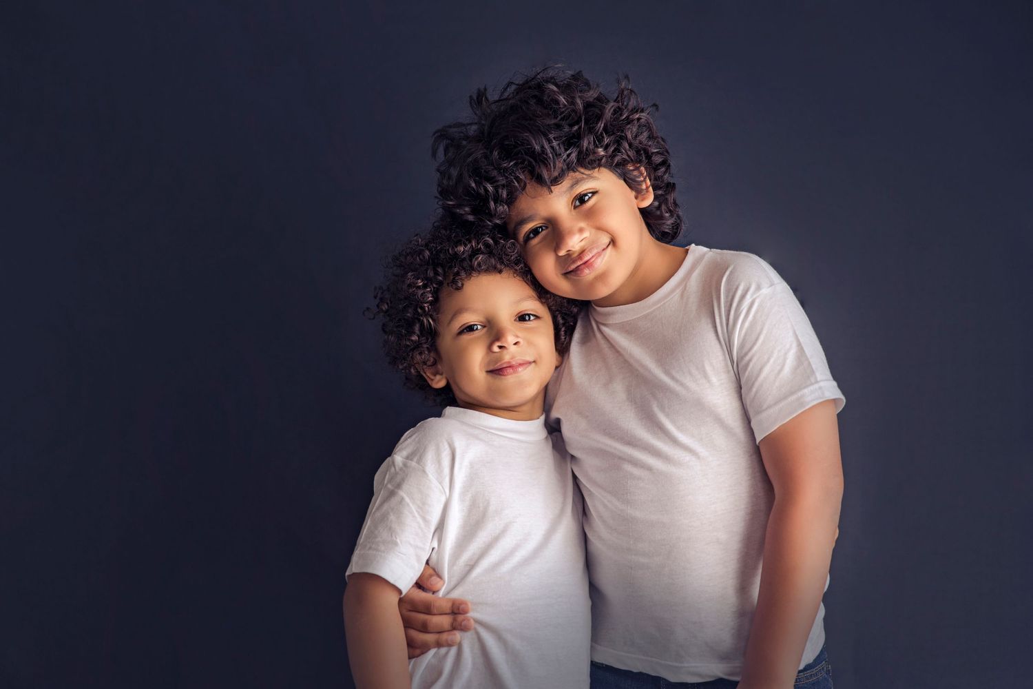 two boys brothers on a black backdrop and white t-shirts detres photography