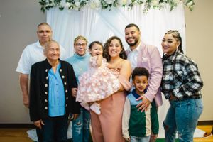 Extended family portrait with multiple generations in coordinated casual outfits.