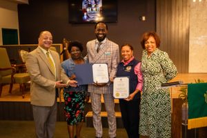 Group gathers for award presentation ceremony in church or community center.