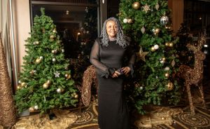 Holiday party setup with decorated Christmas trees and gold accents.