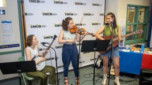Musicians perform with violin and other instruments at community event.