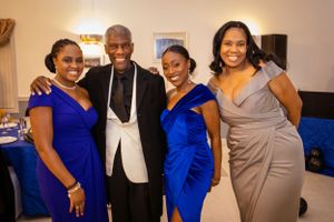 A formal event with people wearing royal blue and gray formal attire at a banquet hall.