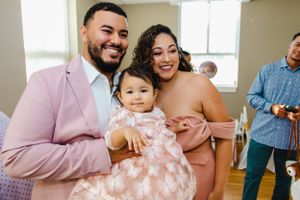 Family gathering in a bright room with pink and white decor.