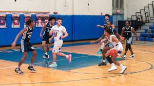 Basketball players competing in an indoor gymnasium during a game.