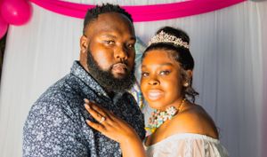 Formal portrait of couple in evening wear with sparkly crown and black attire.
