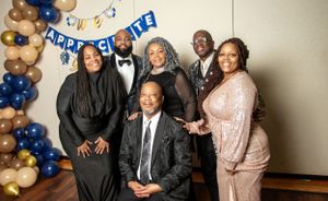 Formal celebration event with balloons and decorations featuring group photo.
