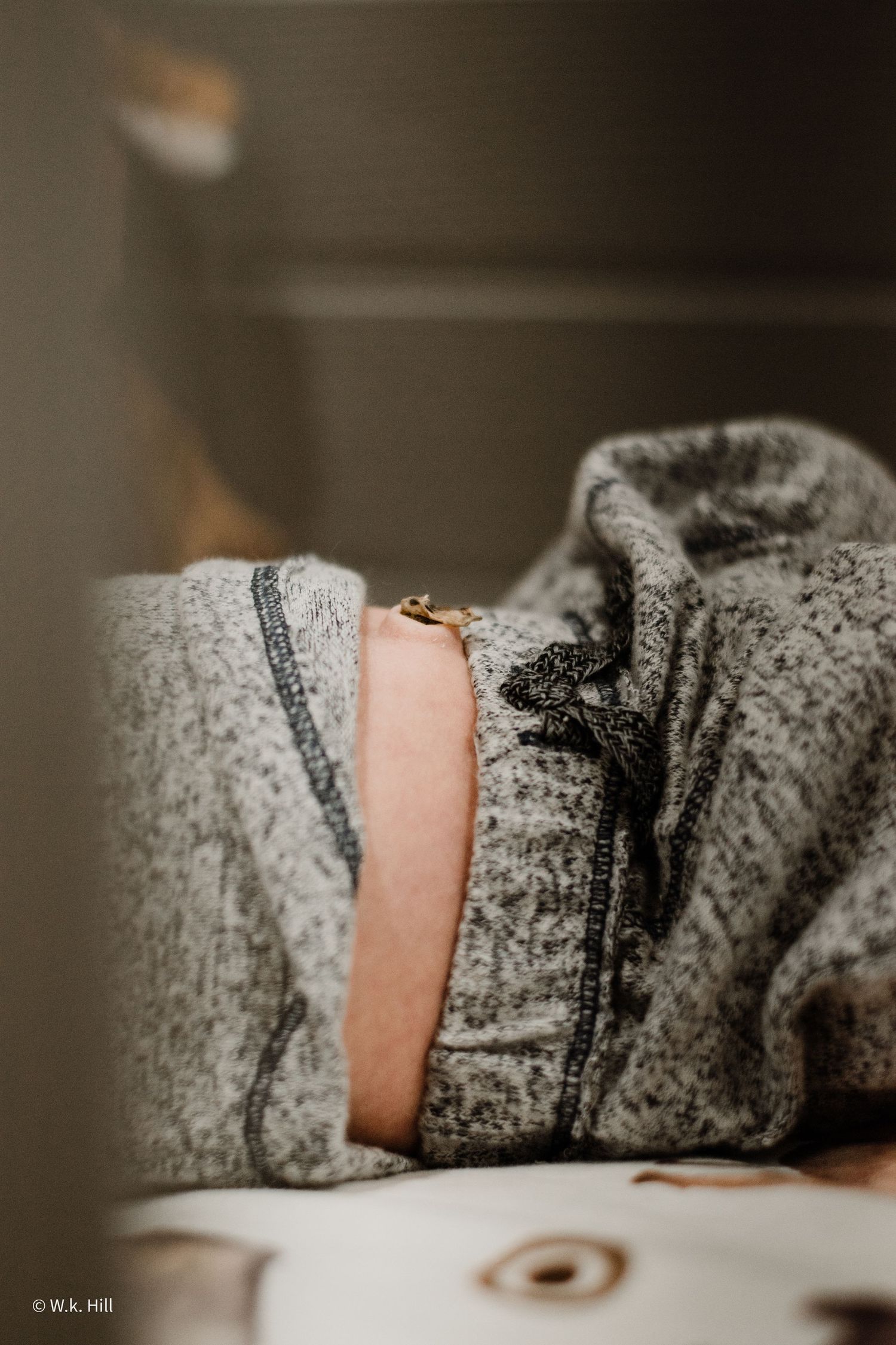 Close-up detail of grey textured fabric with zipper.