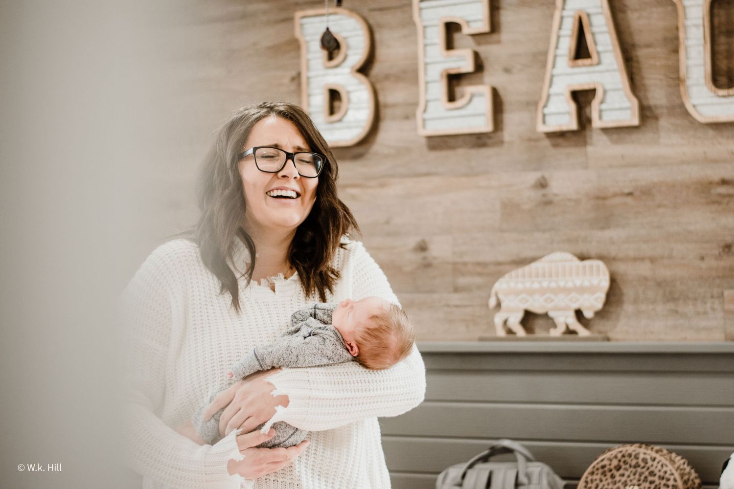 A joyful nursery scene with decorative letters spelling BEAU on wooden wall.