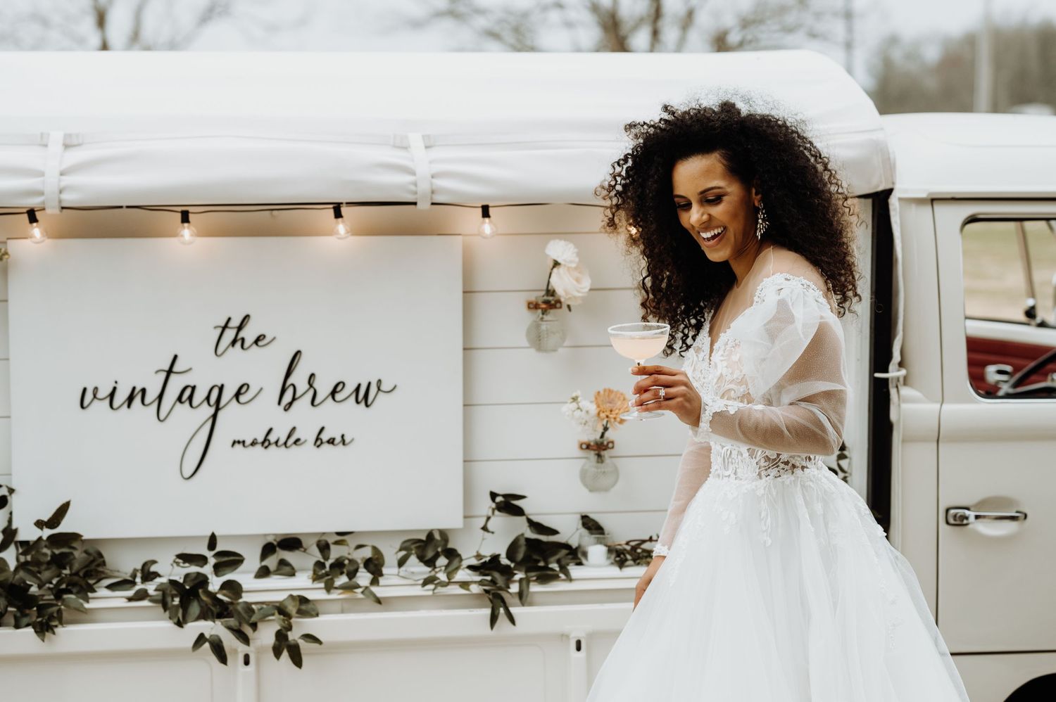 White vintage van with mobile bar branding and festive decor.