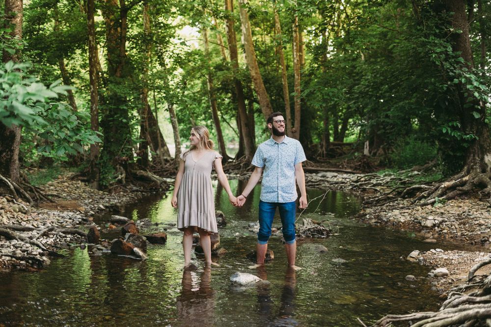 Romantic woodland creek photoshoot with natural lighting filtering through trees.