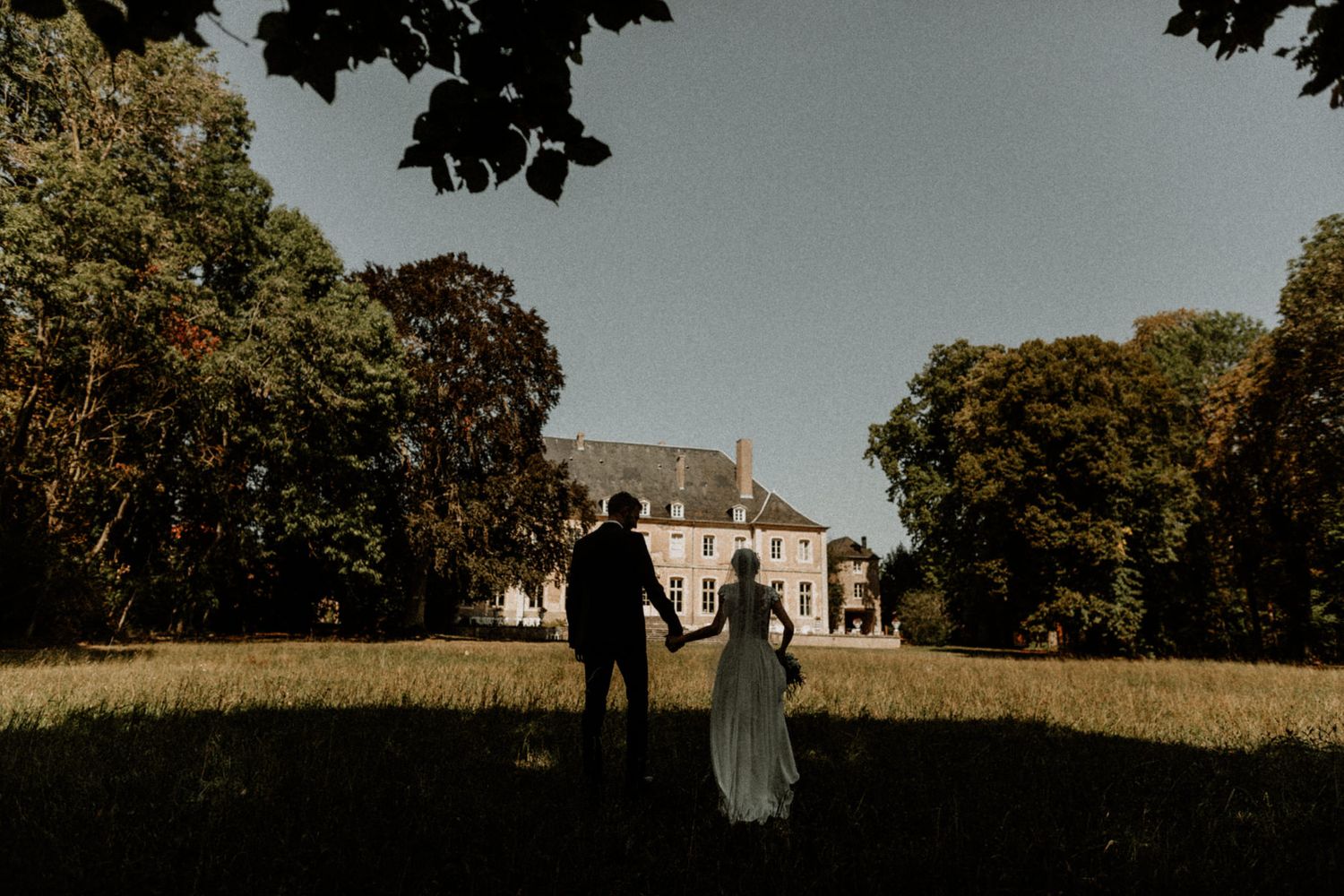 bride and groom walking at the chateau de saulxures