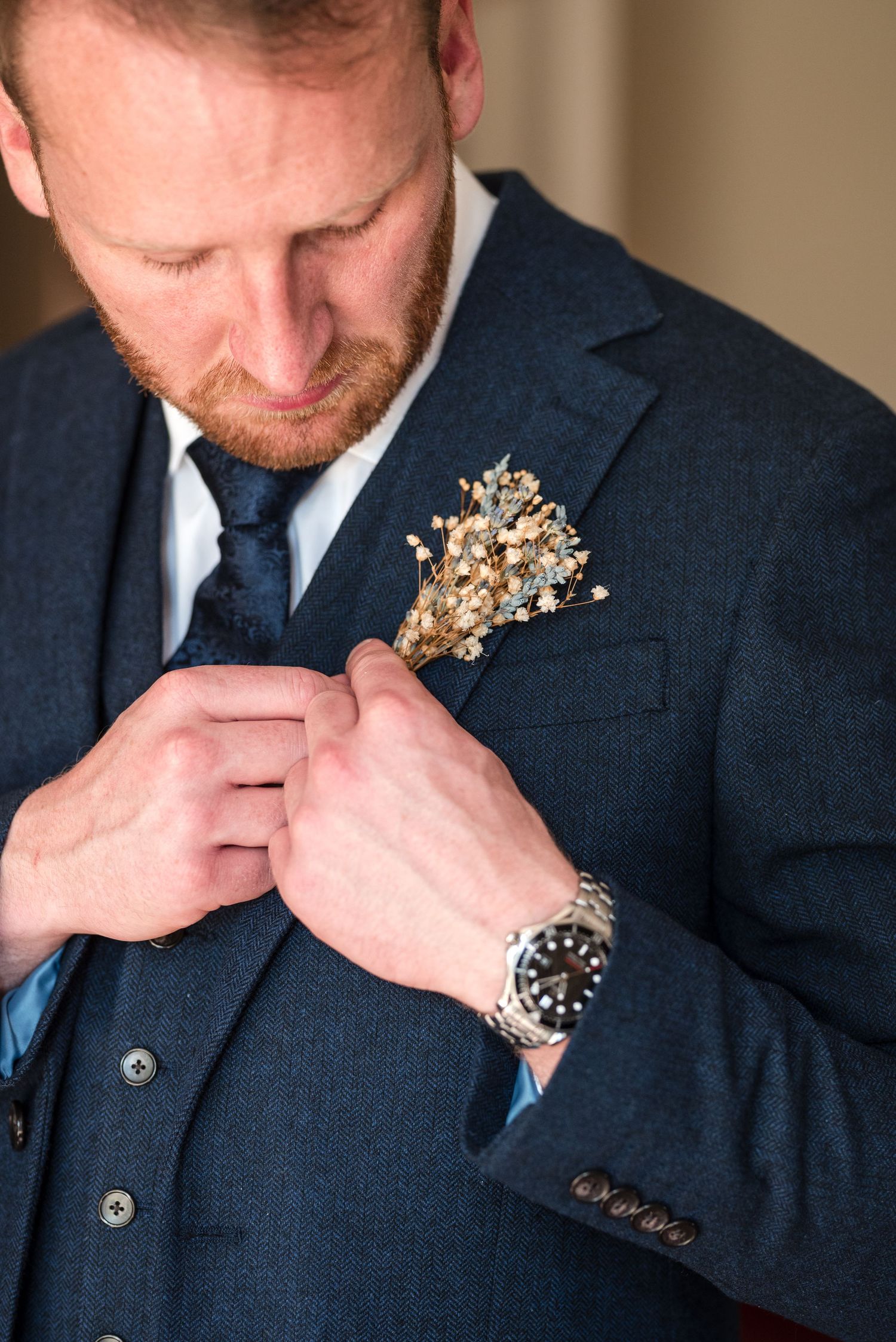 groom fixing Boutonnières to suit