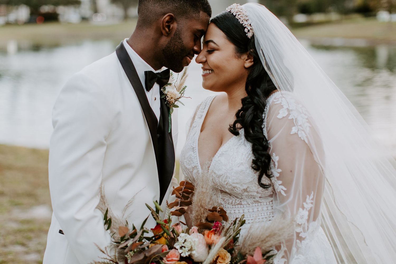 Elegant wedding couple shares romantic moment with floral bouquet.