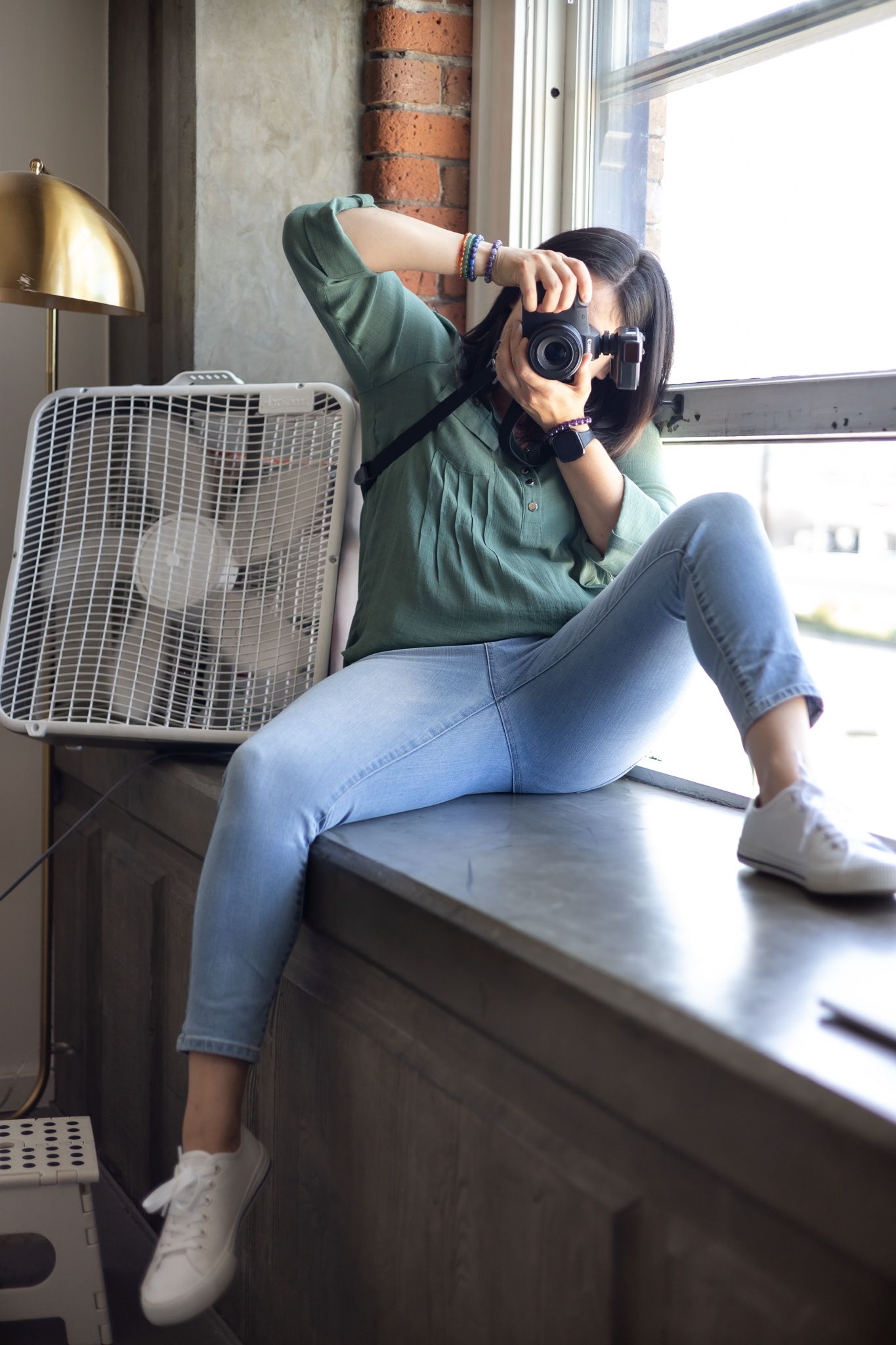 Kristina Pearl Photographer personal branding photographer in action sitting on window taking photo