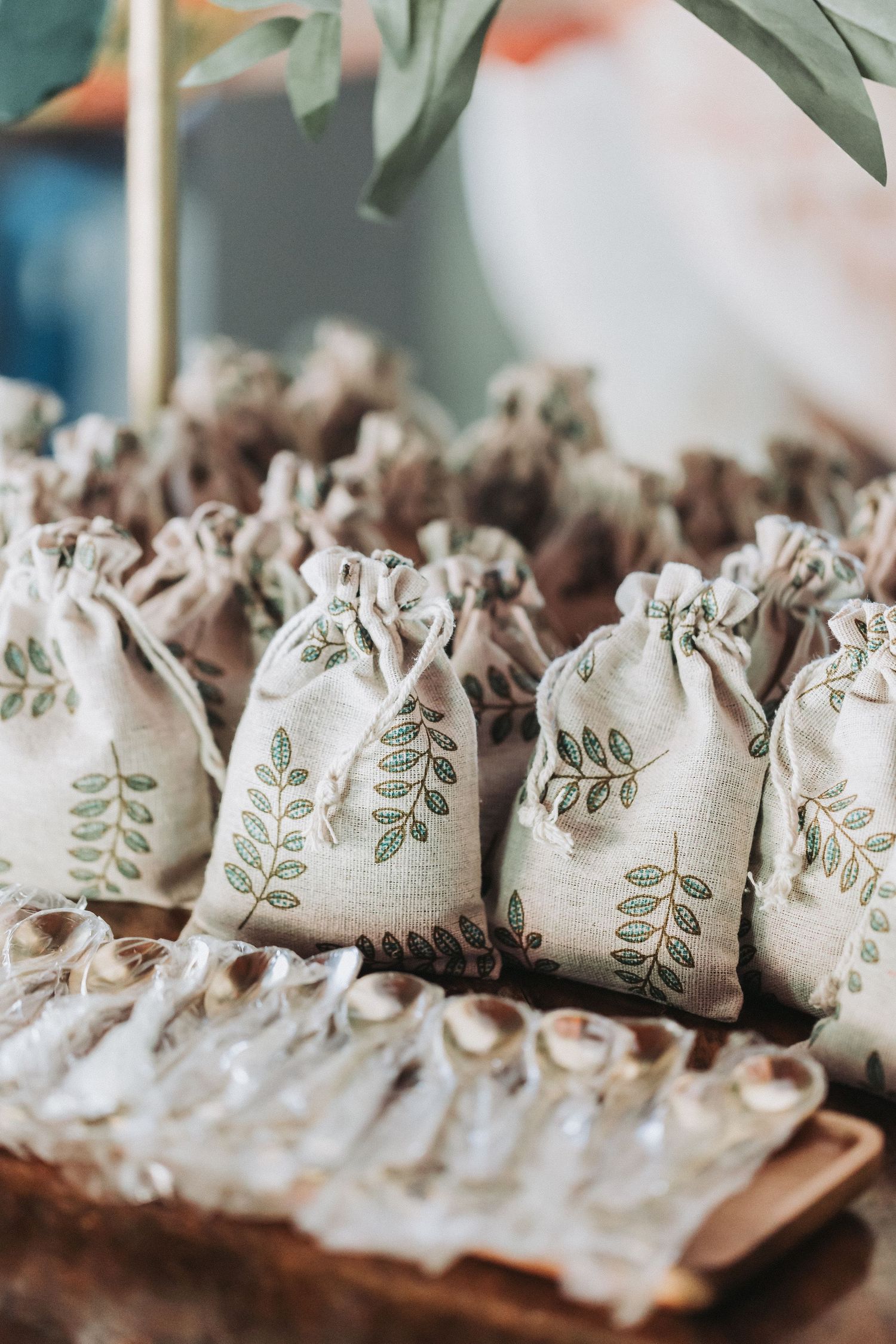 Small fabric favor bags with leaf designs arranged neatly in rows.