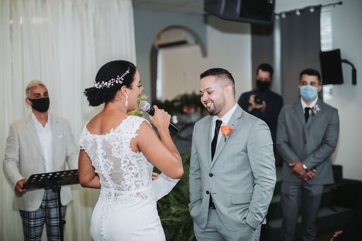 Wedding ceremony scene showing couple sharing laughter in a light-filled venue.