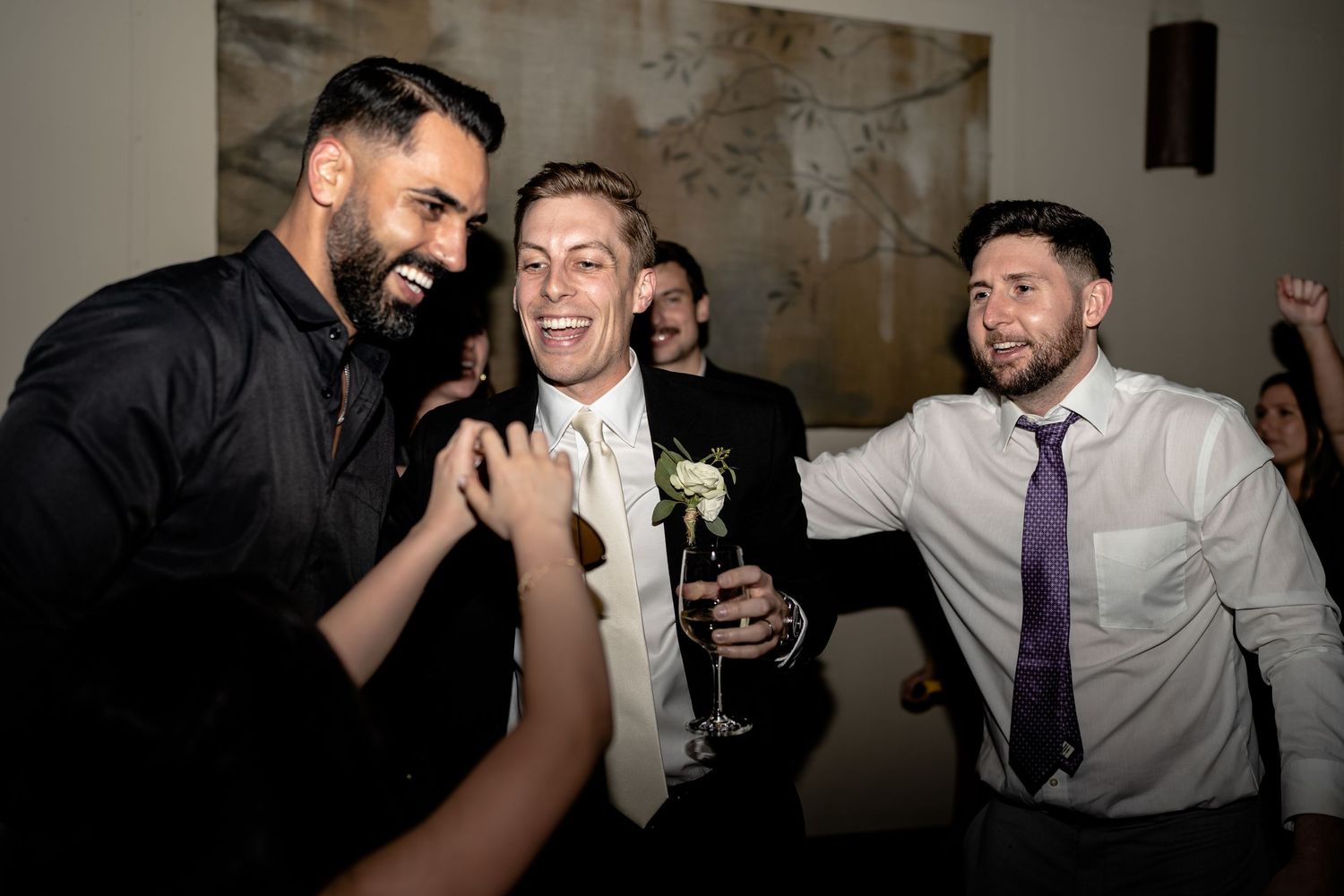 Wedding guests celebrating and laughing together during reception party.