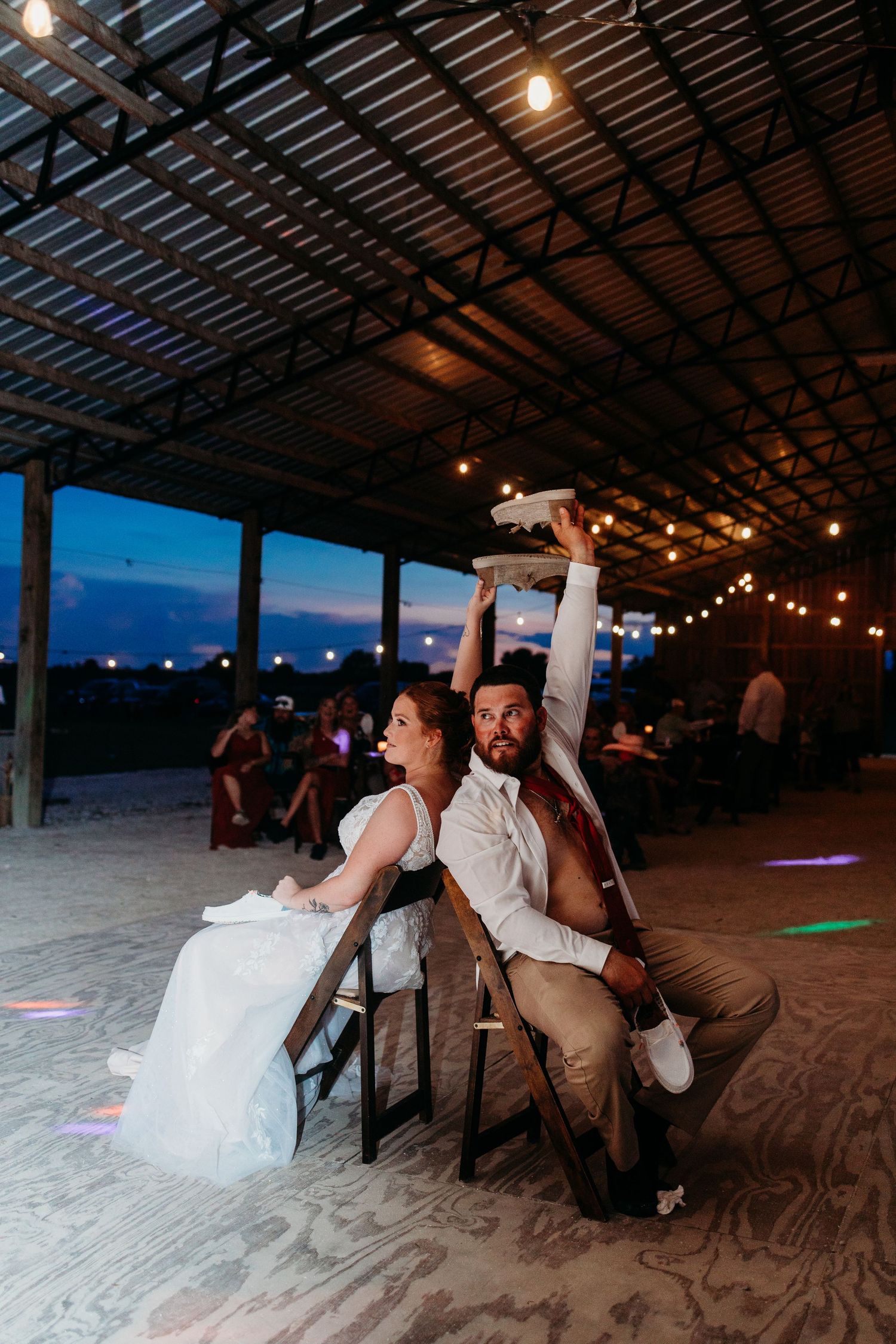A couple performs a coordinated chair dance routine at their wedding reception.