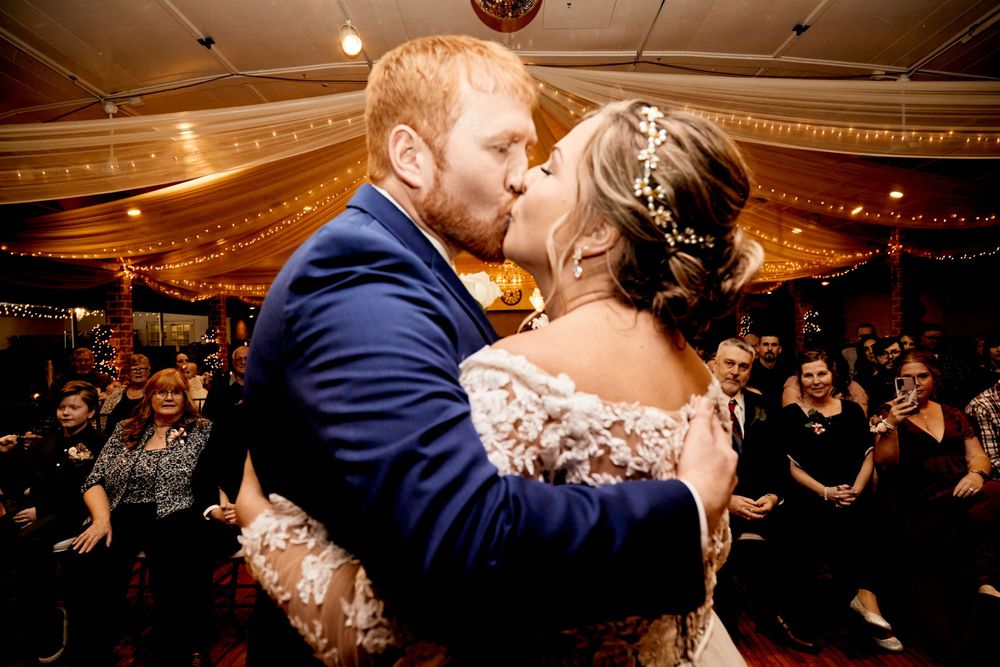 Romantic first dance moment under warm lighting at wedding reception.