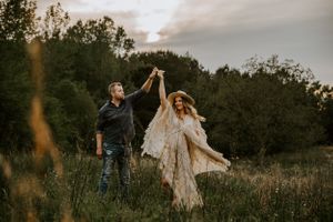 Golden hour outdoor photoshoot in rustic field with flowing dress.