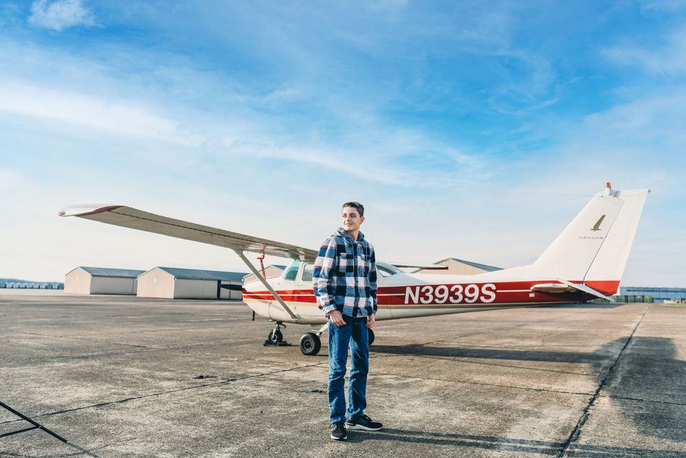 Small aircraft parked on runway under bright blue sky.