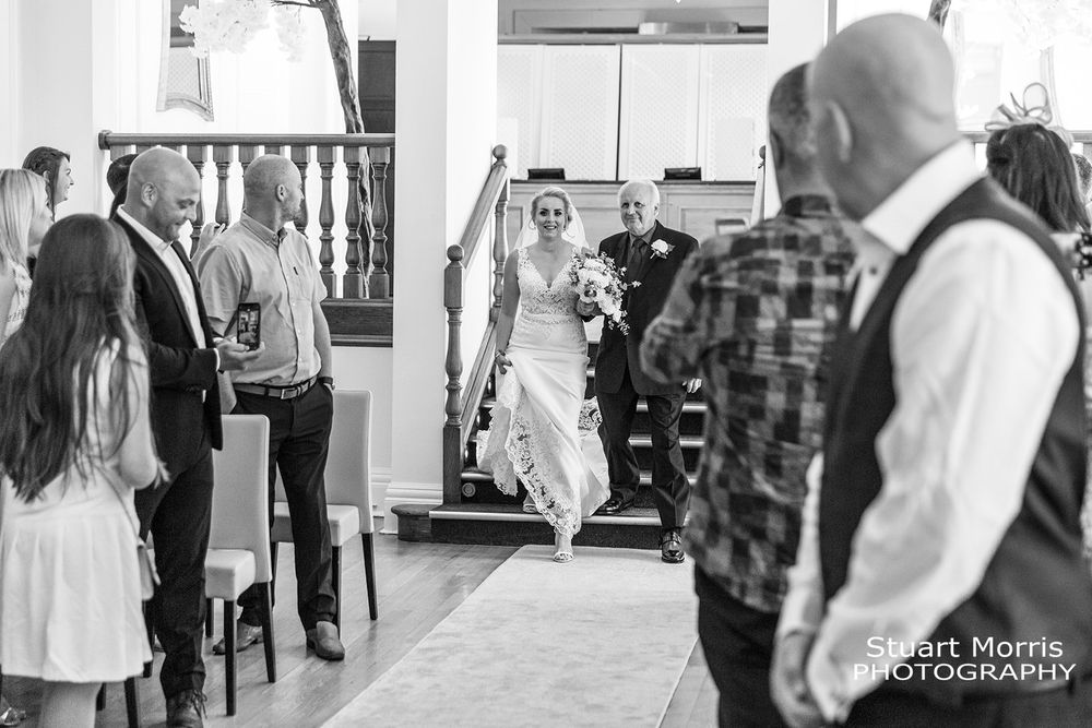 Bride walks down the stairs to the ceremony at west tower country house. Lancashire wedding photographer.