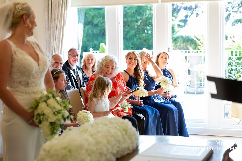 Bridesmaids laughing on the front row during the wedding ceremony. West tower weddings. Ormskirk wedding photography.