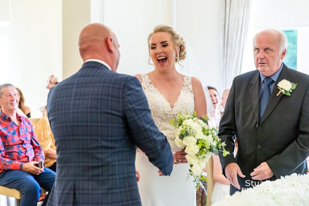 Bride laughs as her grandad rolls his eyes during the ceremony at west tower. Ormskirk wedding photographer.