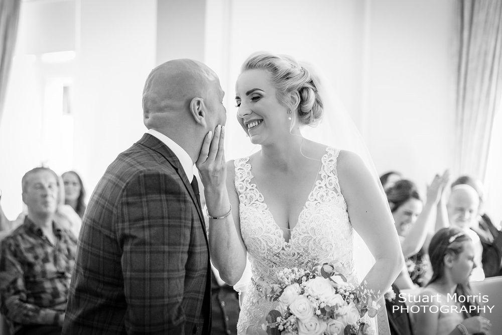 Bride holding the grooms face before their first kiss as husband and wife. West tower wedding photographer.