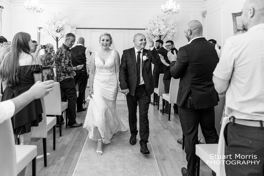 Bride and groom walk up the aisle in the ballroom at west tower. Country house wedding photography.