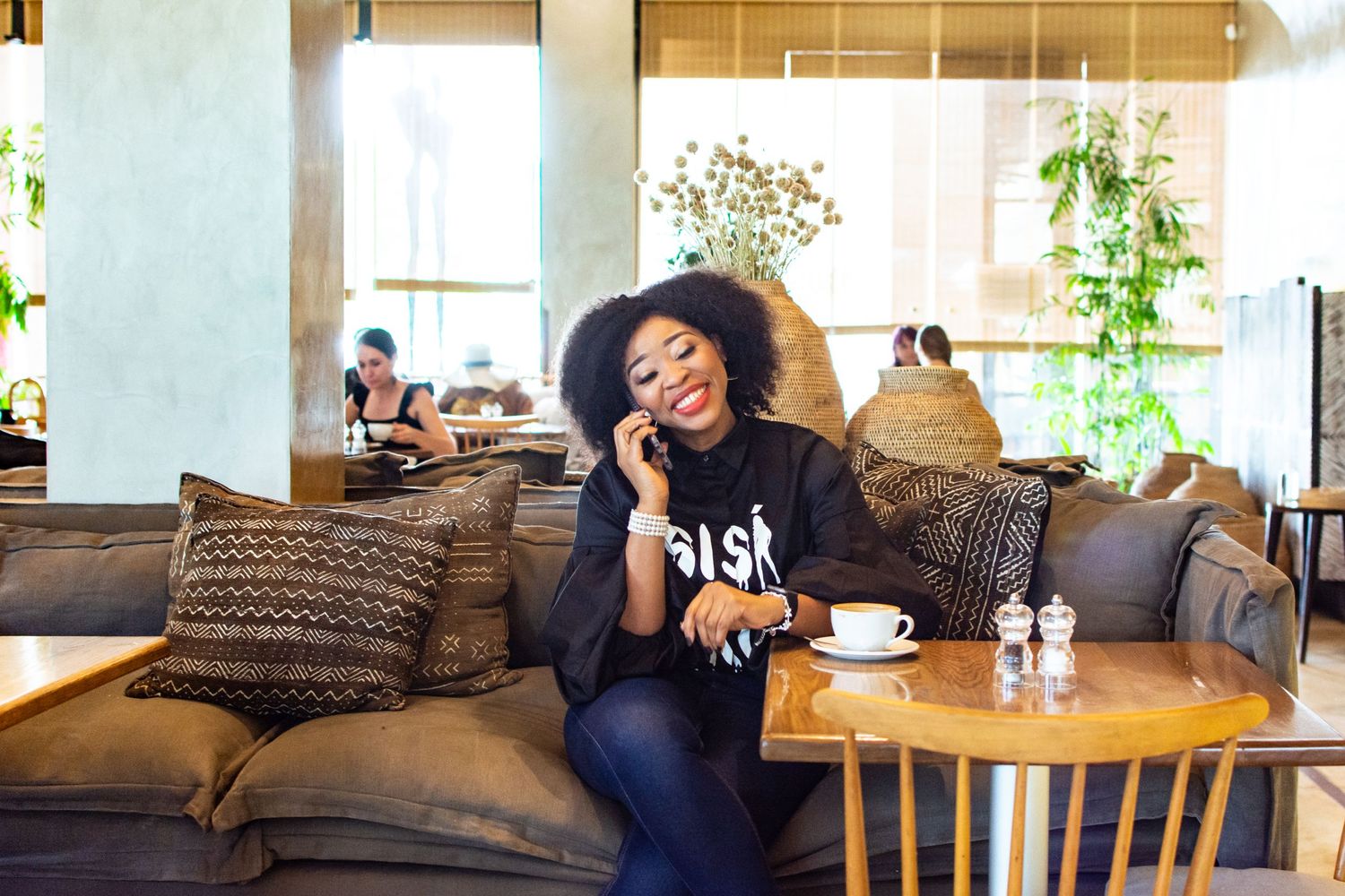 Relaxed cafe scene with comfortable couch seating and coffee cup in modern setting.
