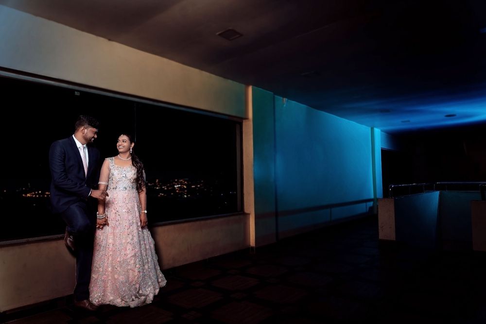 Evening portrait of couple in formal wear against city lights backdrop.