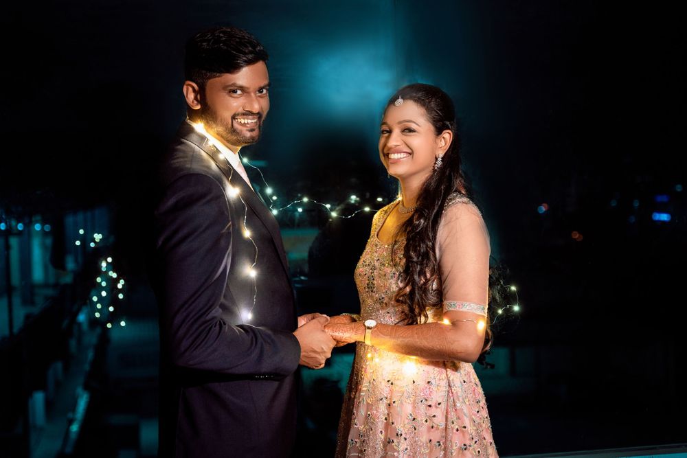 Romantic evening portrait with fairy lights at an outdoor venue.