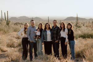 A group portrait in a desert landscape with saguaro cacti in the background.