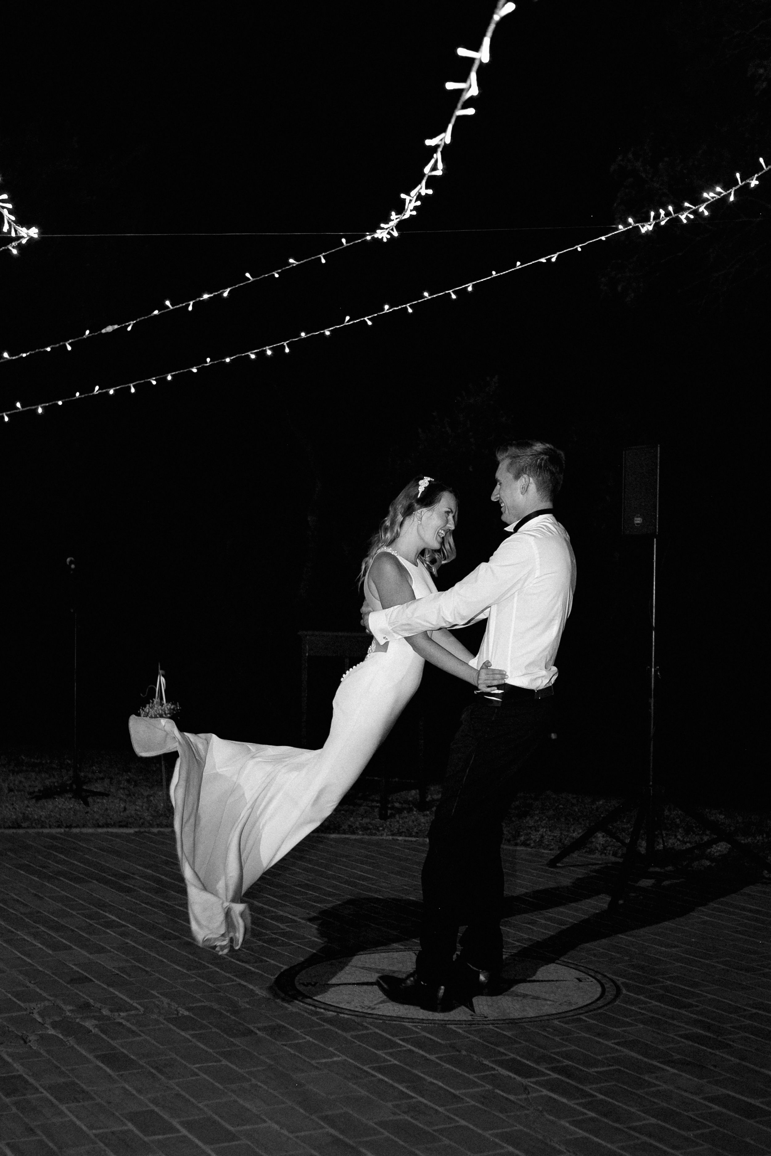 A groom lifting his bride high up in the air during their first dance at The Victoria Falls Hotel.