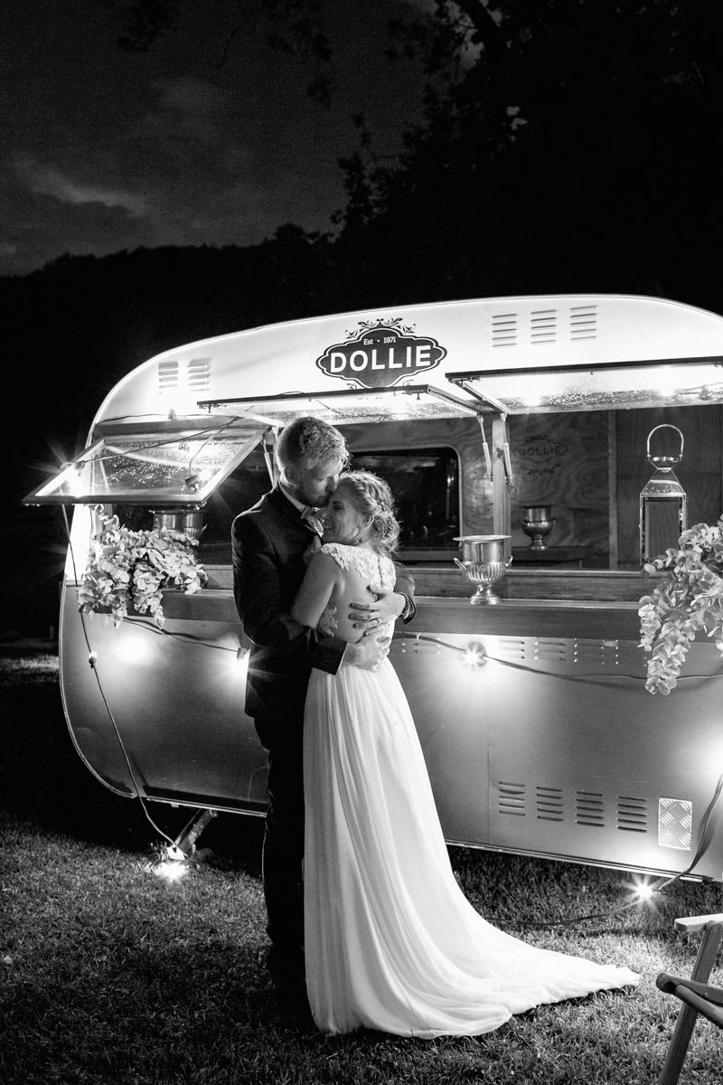 Heinrich & Megan hugging in front of Dolly, their mobile wedding champagne bar.