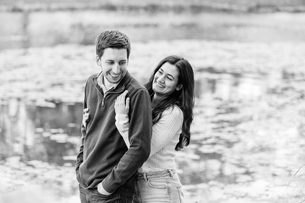 A couple poses for romantic black and white engagement photos outdoors.