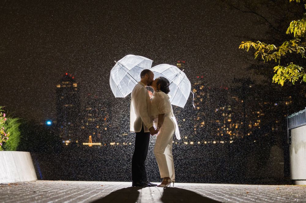 Romantic nighttime engagement photos with city lights twinkling in background.